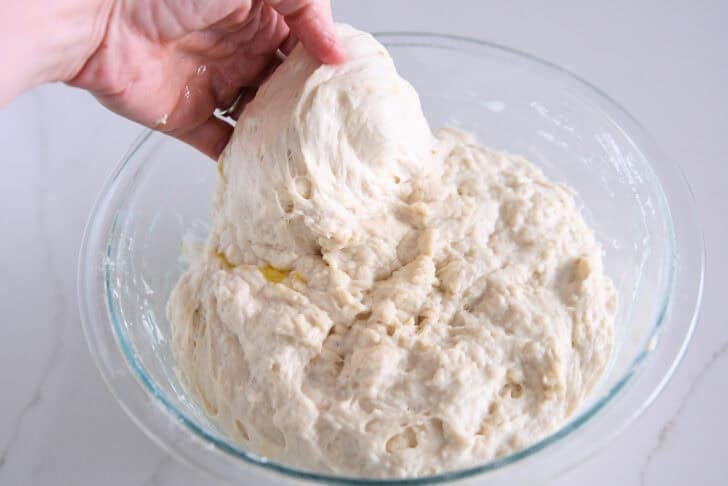 Spread and fold the focaccia dough into a glass bowl.
