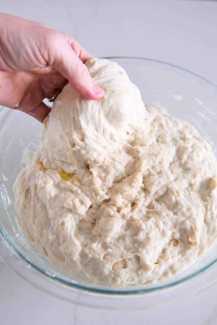 Spread and fold the focaccia dough into a glass bowl.