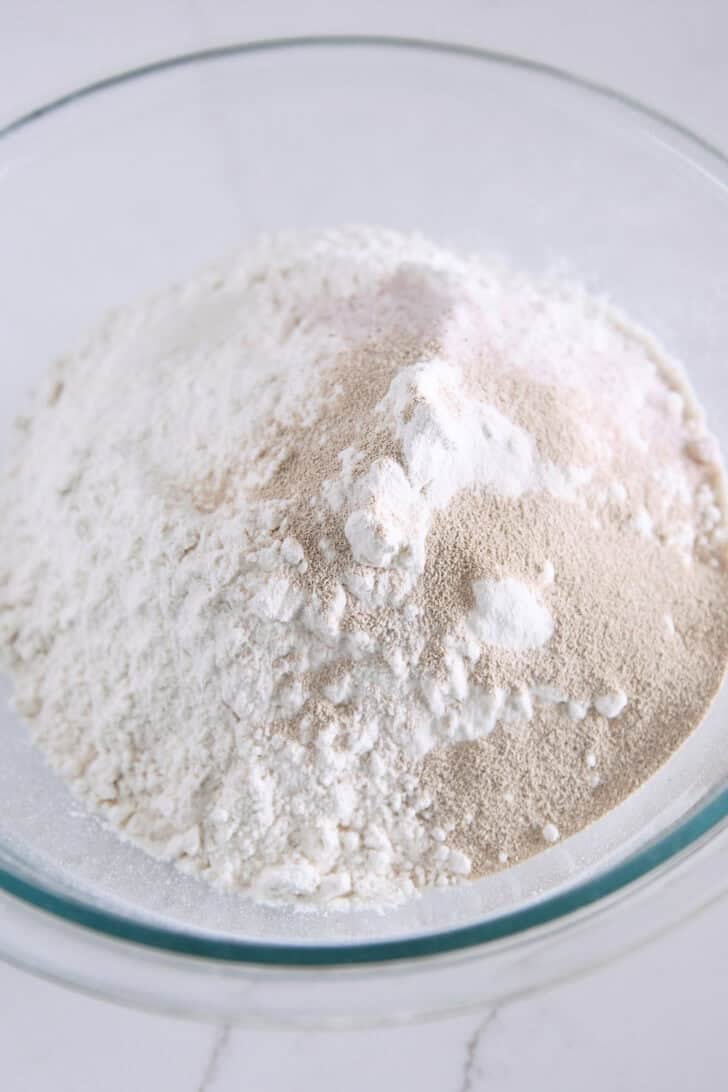 Glass bowl with flour, yeast and salt.
