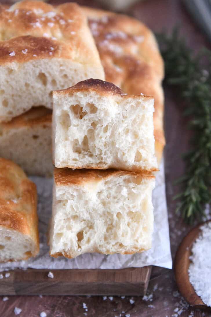 Two fluffy focaccia halves on white parchment paper.