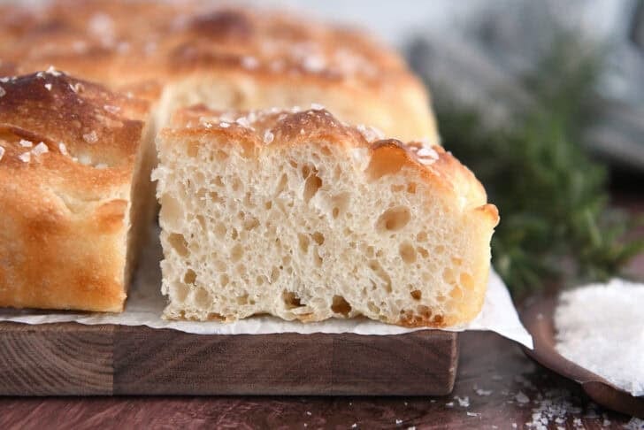 Square slices of fluffy focaccia bread on white parchment paper.