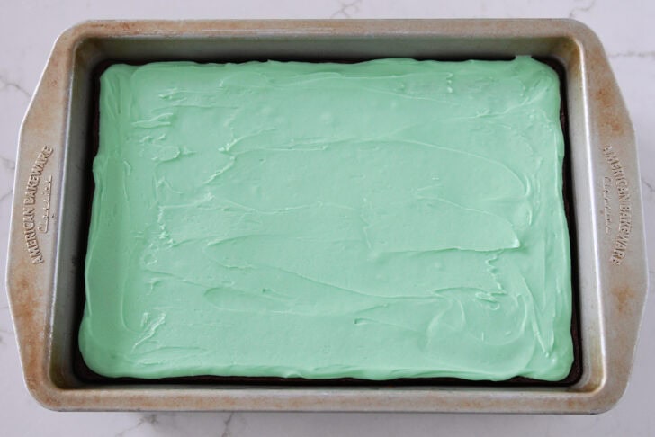 Metal 9X13-inch pan with brownies and mint frosting.