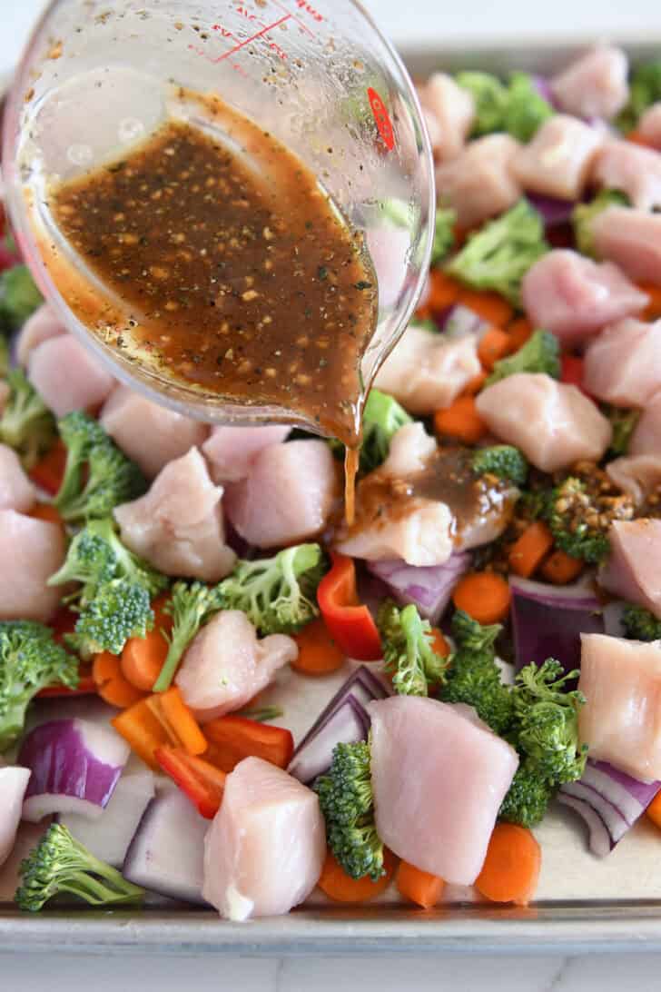 Pour the honey garlic sauce over the chicken, broccoli, bell peppers, and carrots on a sheet pan.