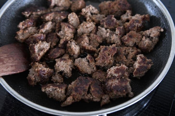 Crunchy chunks of ground beef cooked in a frying pan.
