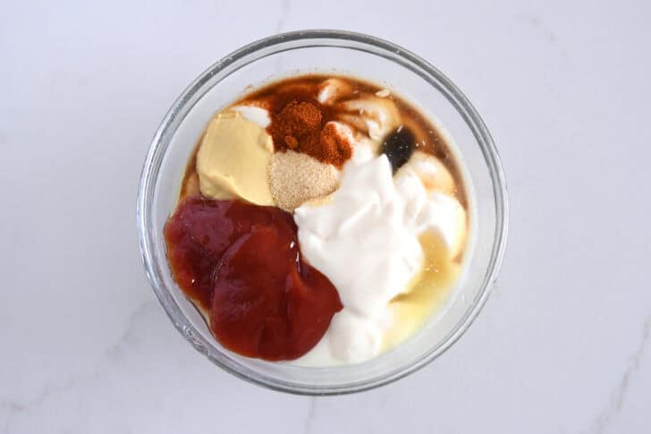 Combine ketchup, mayonnaise, mustard, garlic powder, Worcestershire sauce, paprika, and vinegar in a glass bowl.