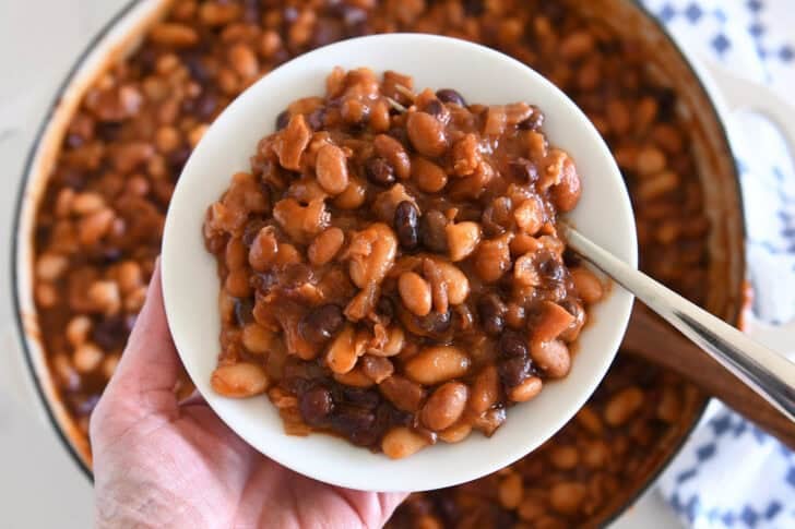 Serving of calico baked beans on white plate.