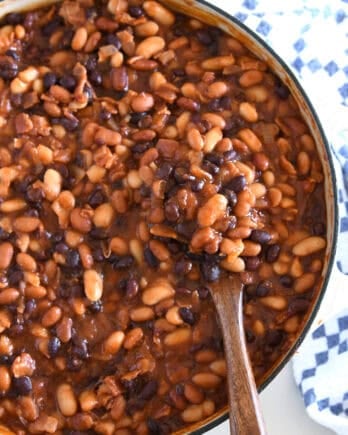 Wooden spoon scooping up calico baked beans.