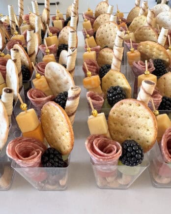 Mini charcuterie cups on white counter.