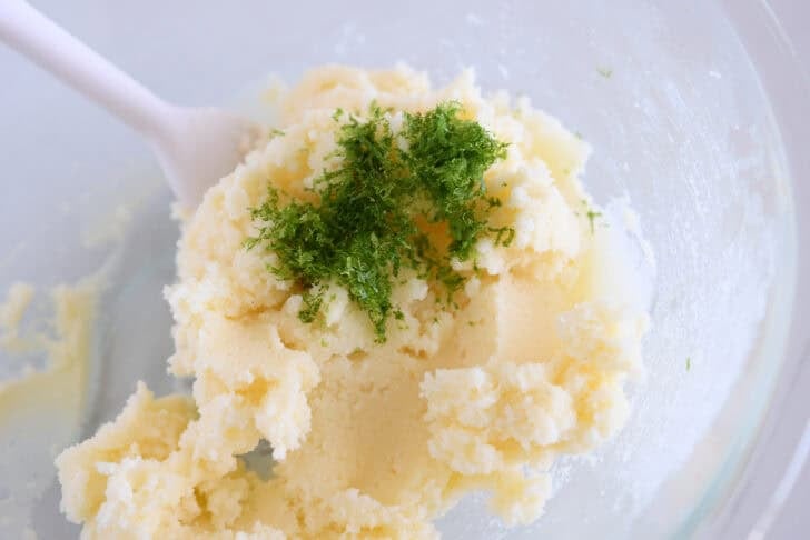 Glass bowl with creamed sugar, butter and fresh lime zest.