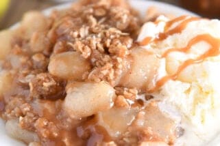 Double stack of white plates with serving of caramel pear crisp and vanilla ice cream.