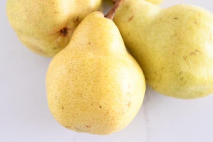 Three golden bartlett pears.