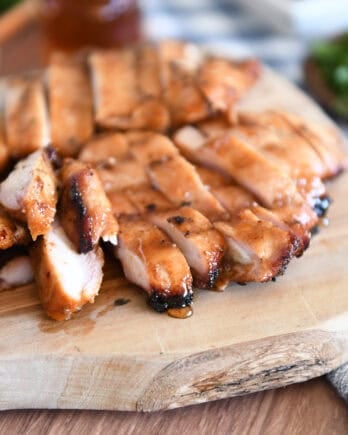Wood tray with sliced pieces of grilled chicken.