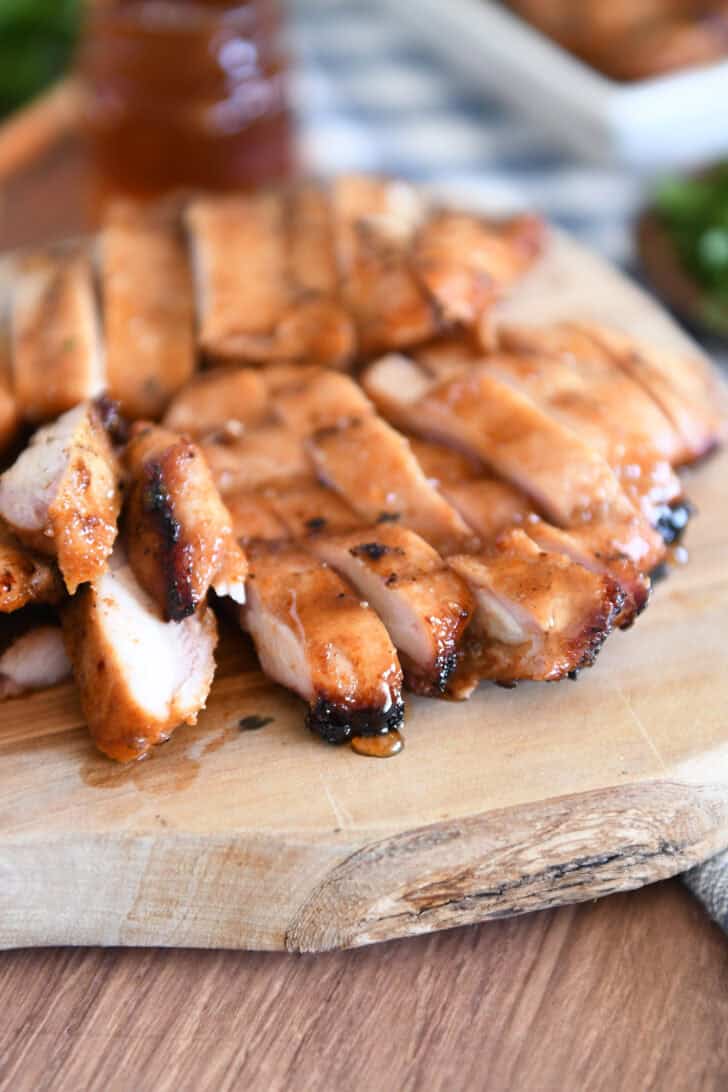 Wood tray with sliced pieces of grilled chicken.