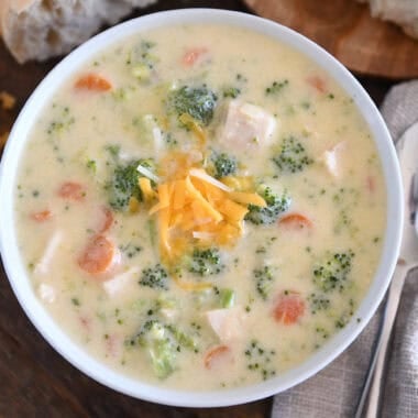Soup bowl with creamy soup, chicken, broccoli, carrots, cheese, and chicken.