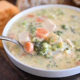 Soup bowl with creamy soup, chicken, broccoli, carrots, cheese, and chicken.