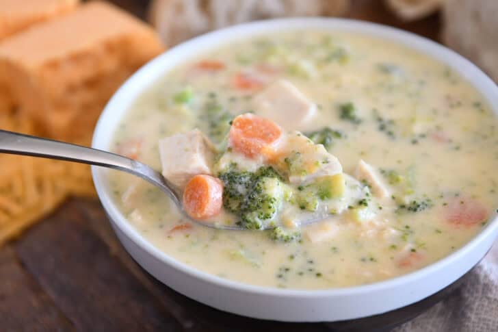 Soup bowl with creamy soup, chicken, broccoli, carrots, cheese, and chicken.