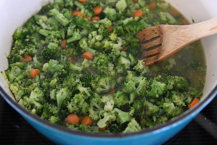 Soup pot with cooked broccoli and carrots.