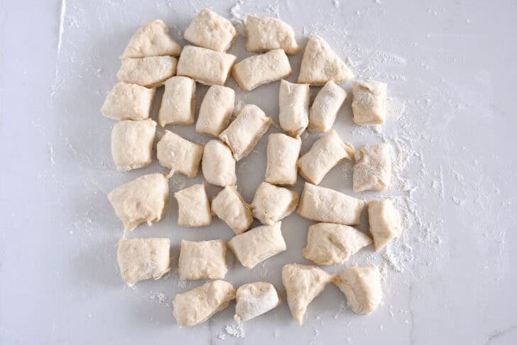 34 pieces of dough on lightly floured counter.