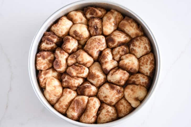 Cinnamon and sugar coated buttery dough in circle baking pan.