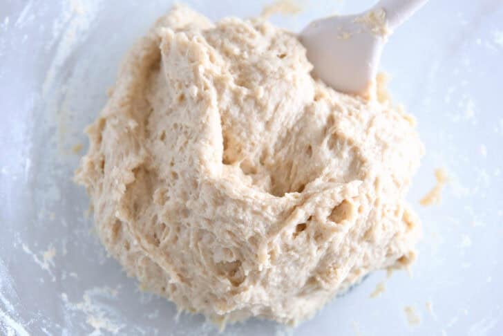Wet roll dough mixed in glass bowl.