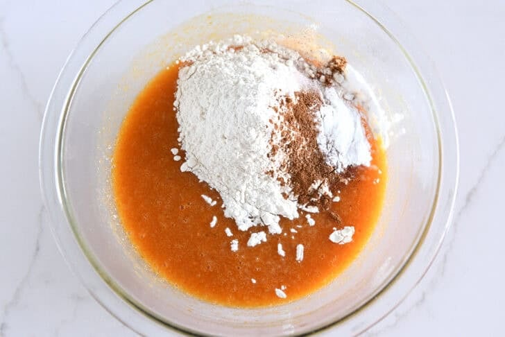 Glass bowl with canned pumpkin, flour, cinnamon and baking soda.