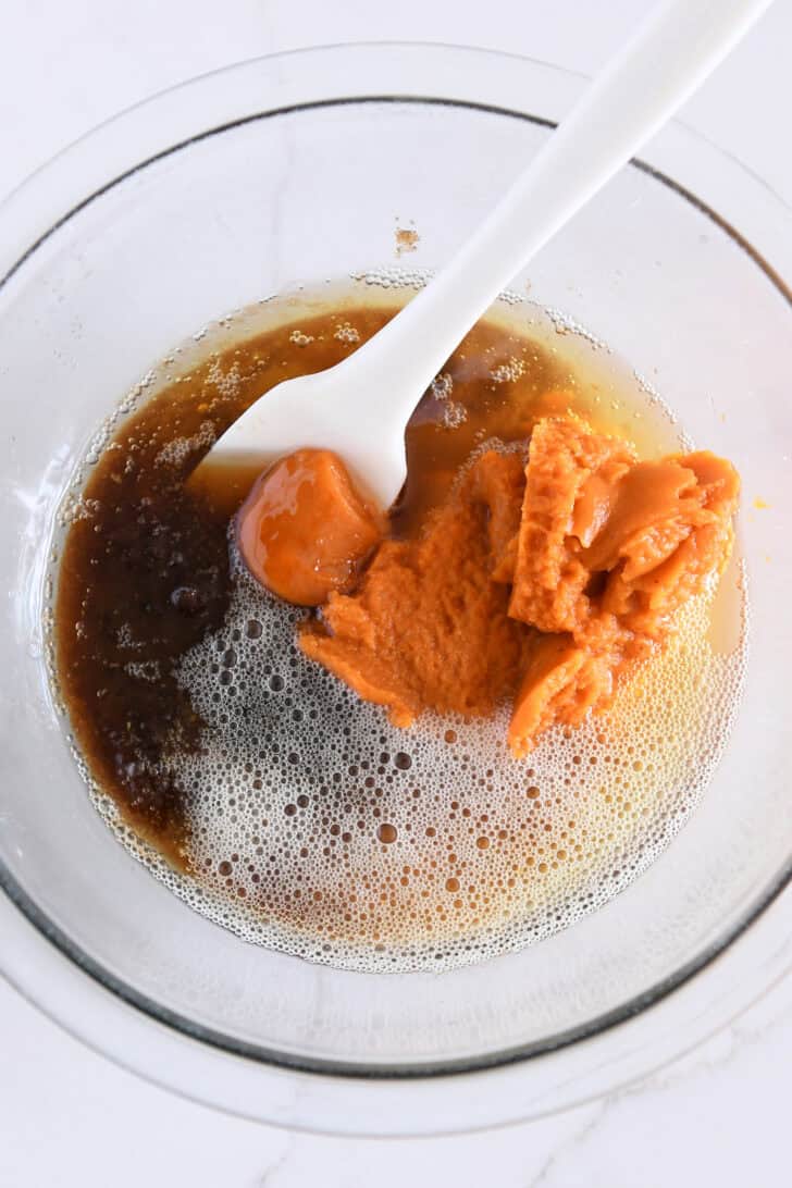 Glass bowl with brown butter, canned pumpkin, and brown sugar.
