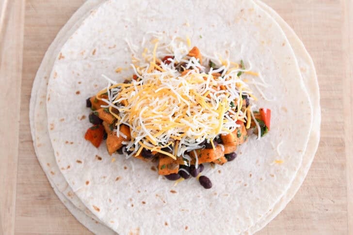 Tortilla with black bean sweet potato filling and cheese in the middle.