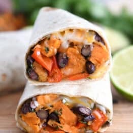 Two halves of black bean sweet potato burritos stacked on each other.