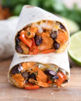 Two halves of black bean sweet potato burritos stacked on each other.