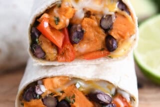 Two halves of black bean sweet potato burritos stacked on each other.