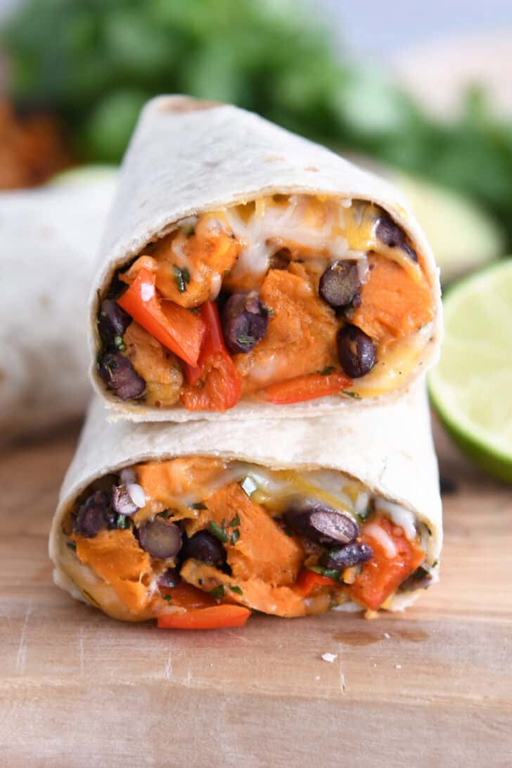 Two halves of black bean sweet potato burritos stacked on each other.