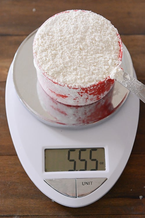 Top view of a red measuring cup on a kitchen scale. 