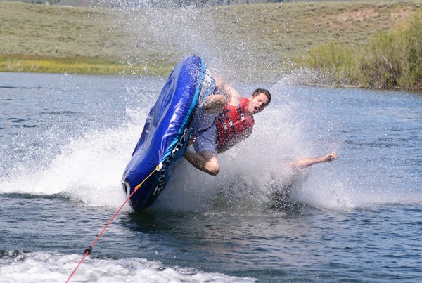 a man crashing into a lake off of a tube