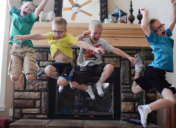 Four little boys jumping in the air. 