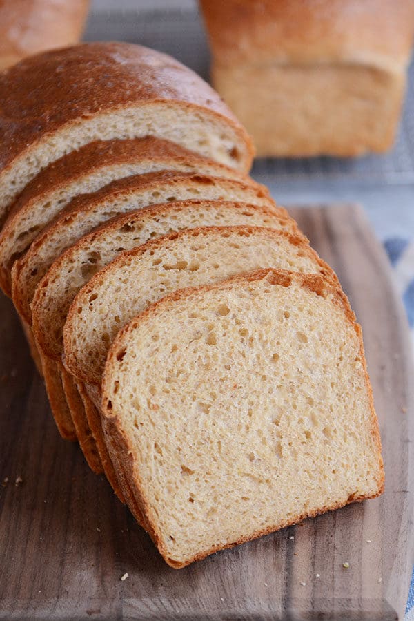 A loaf of homemade wheat bread with five thick slices cut off.
