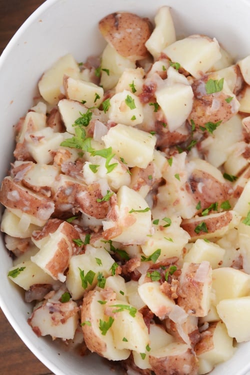 A large white bowl of german potato salad.