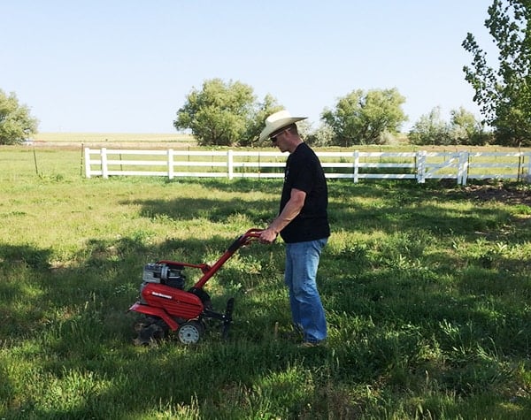 A man using a rotatiller. 