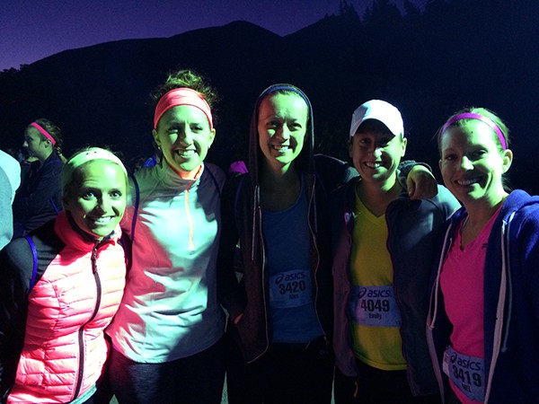 A group of woman at early dusk waiting to start a race.