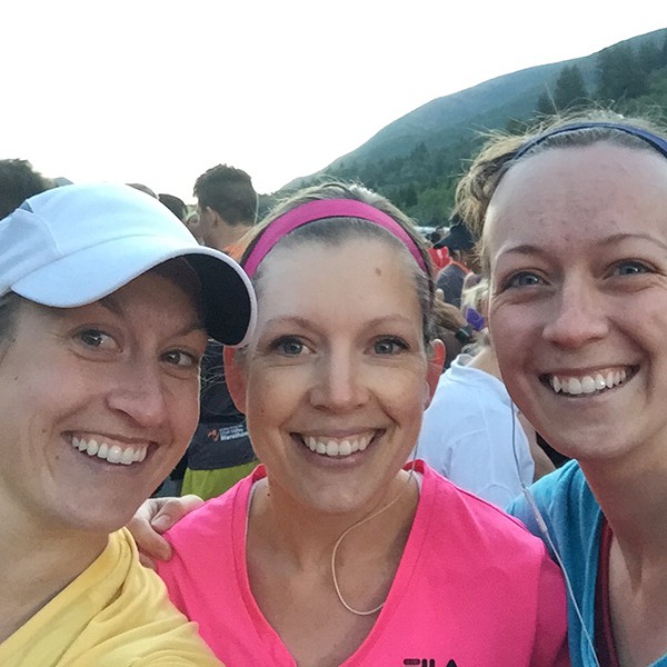 Three women standing together ready to run a race.