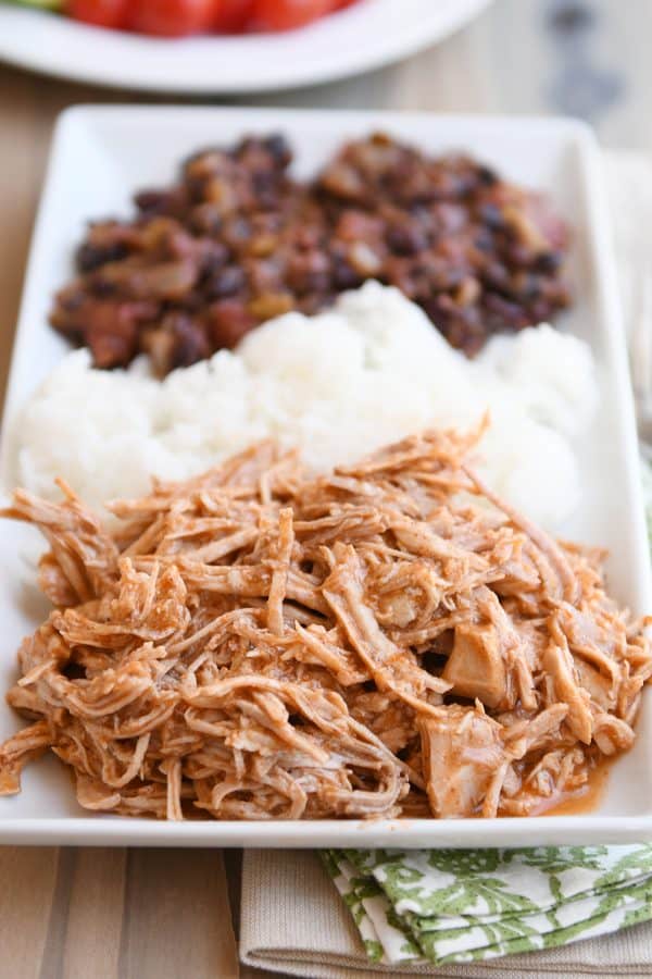 Instant pot Mexican pork on white tray with rice and beans.