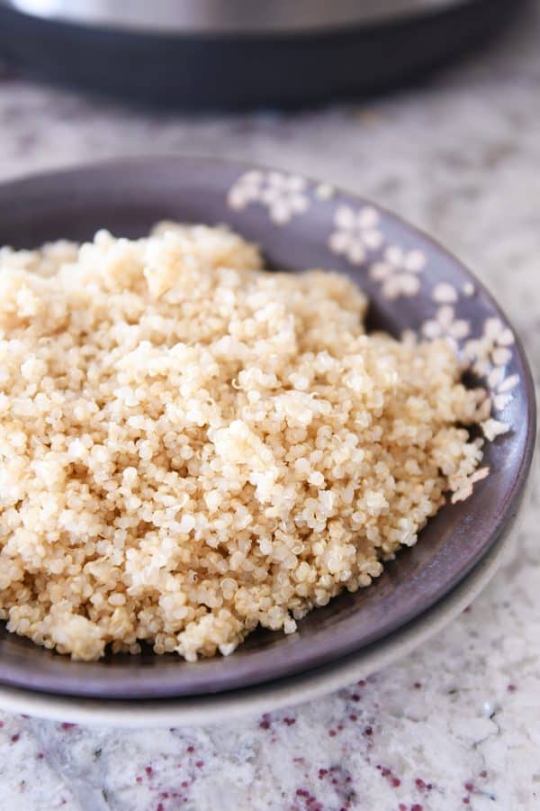 Brown bowl of fluffy cooked quinoa.