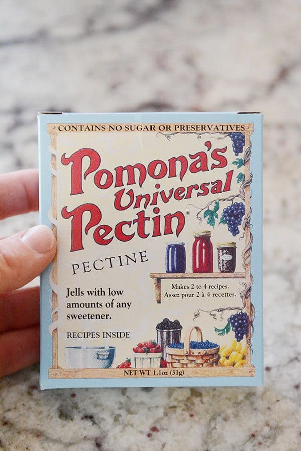 A hand holding a box of Pomona's Universal Pectin.