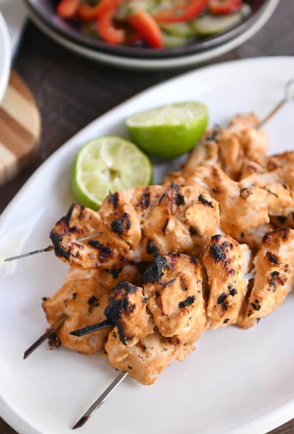 Almond coconut milk chicken satay on white platter.