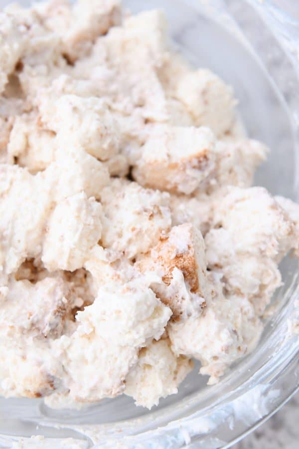 Glass bowl of cream coated angel food cake pieces.