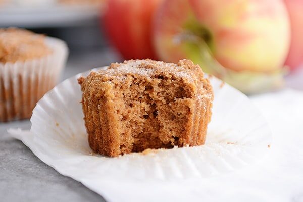 A cinnamon and sugar dusted applesauce muffin with a bite taken out.