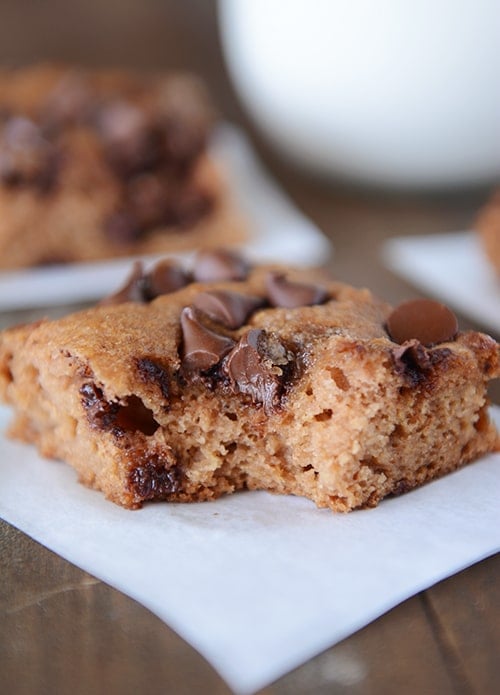 A piece of chocolate chip snack cake with a bite taken out. 