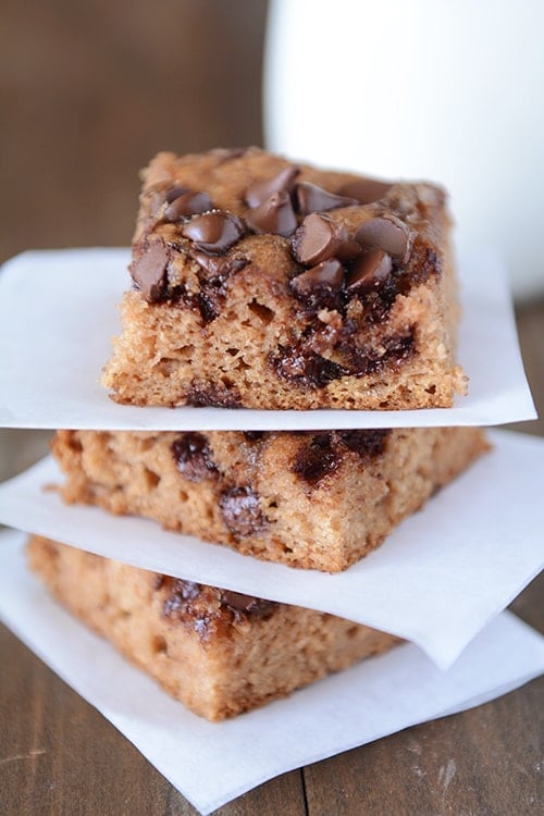 Pieces of chocolate chip cake stacked between layers of parchment.