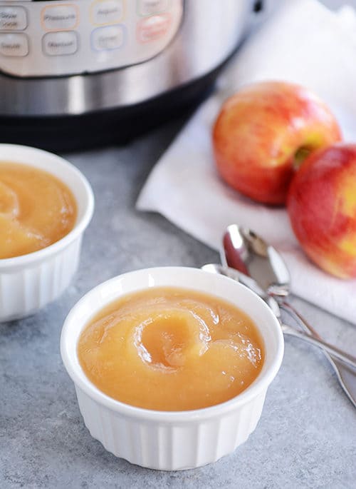 Small white ramekins filled with applesauce.