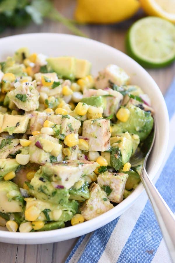 Avocado chicken salad all mixed up in white serving bowl.