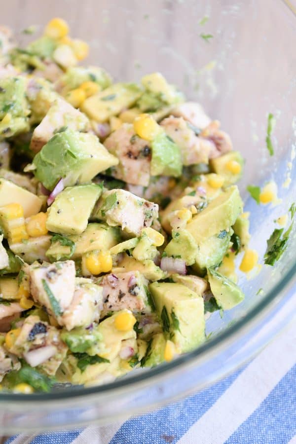 Avocado chicken salad all mixed up in glass bowl.